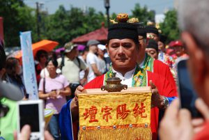 A vibrant cultural procession featuring traditional clothing and ceremonial artifacts.